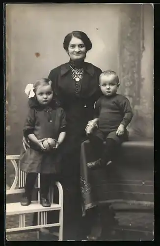 Foto-AK Mutter mit ihren Kindern mit Spielzeug in Studiokulisse