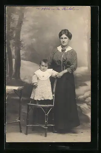 Foto-AK Mutter in Bluse und Rock neben ihrem Kind in Studiokulisse, B. Michel 1914