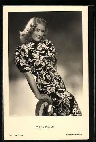 AK Schauspielerin Marte Harell sitzt lächelnd auf einer Stuhllehne