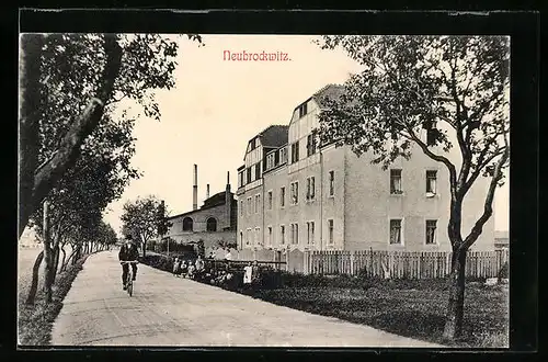 AK Neubrockwitz, Strassenpartie mit Fabrik und Radfahrer