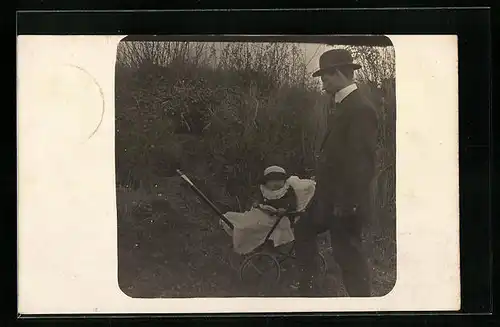 AK Mann betrachtet seinen Sohn im Kinderwagen