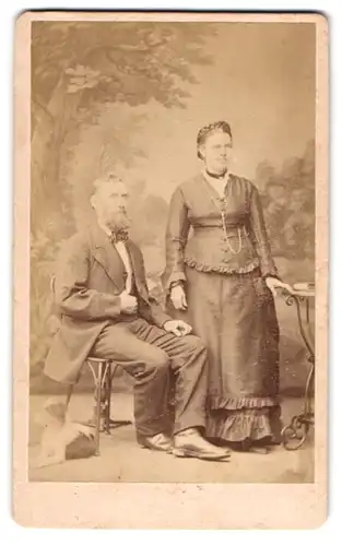 Fotografie Carl Fischer, Fulda, Friedrichstr. 24, Portrait eines elegant gekleideten Paares vor einer Waldstudiolkulisse
