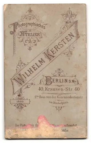 Fotografie Wilhelm Kersten, Berlin S.W. Krausen-Str. 40, Mann im Mantel steht neben einem bedeckten Tisch