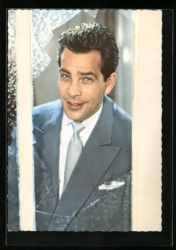 AK Schauspieler Adrian Hoven blickt lächelnd durch ein zersprungenes Fenster