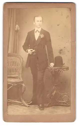 Fotografie unbekannter Fotograf und Ort, Junger Mann mit einem Hut auf dem Tisch