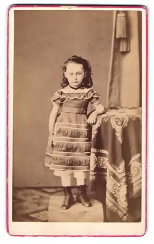 Fotografie H. Sachse, Burg, Kleines süsses Mädchen im Kleid an einem Tisch