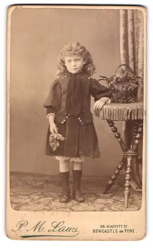 Fotografie P.M Laws, New Castle on Tyne, Blacket Street 38, Kleines Mädchen steht mit einem Tuch in der Hand