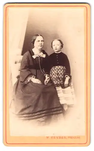 Fotografie W. Seyser, Prenzlau, Königs-Str. 159, Eine ältere Dame mit einer Fliege und einem kleinen Mädchen neben ihr