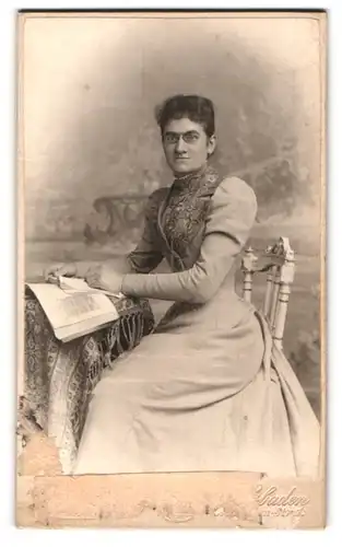 Fotografie A. Bark, Wiesbaden, Musuem-Str. 1, Frau mit sehr schlanker Taille am Tisch mit einem Buch