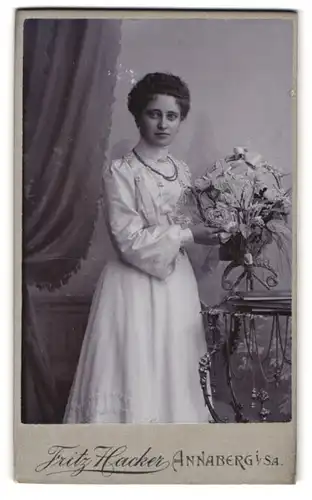 Fotografie Fritz Hacker, Annaberg, Karlsplatz, Junge Dame mit lockigem Haar und Blumenstrauss in der Hand