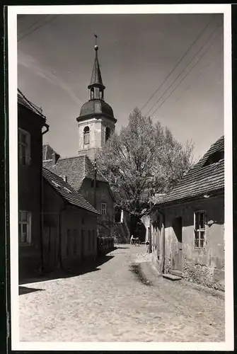 Fotografie Brück & Sohn Meissen, Ansicht Ortrand, Strassenpartie mit Wohnhäusern und Blick zur Kirche