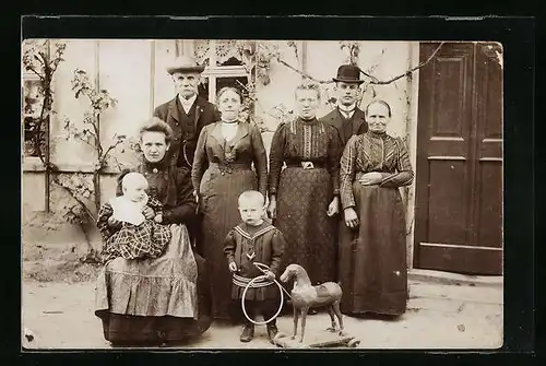 Foto-AK Grossfamilie mit Knabe und Spielzeugpferd
