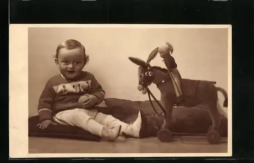 Foto-AK Kleiner Junge mit Spielzeugesel auf Rädern