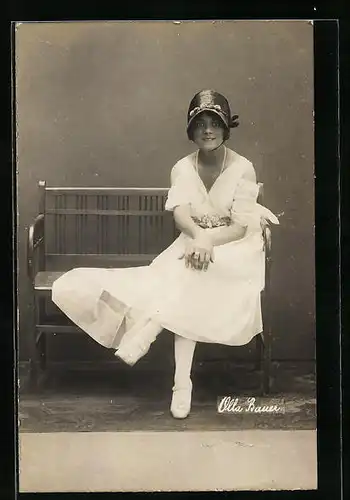 AK Schauspielerin Olla Bauer sitzt auf einer Bank im weissen Kleid
