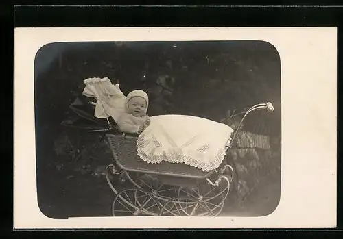 AK Baby im Garten sitzt vergnügt im Kinderwagen