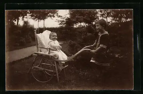 AK Mädchen schiebt des Kinderwagen des Geschwisterchens durch den Garten
