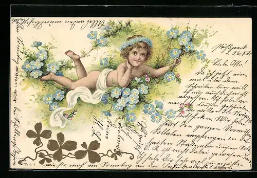 Präge-AK Kleines Mädchen mit Blütenkranz im Haar liegt lachend inmitten blauer Blumen
