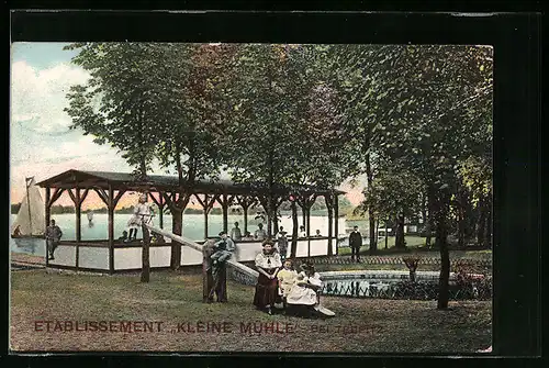 AK Teupitz, Etablissement Kleine Mühle, Garten mit Terrasse am See, Teich und Kindern auf Kletterbrett
