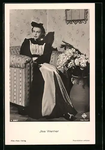 AK Schauspielerin Ilse Werner sitzt im Kleid auf einem Sessel