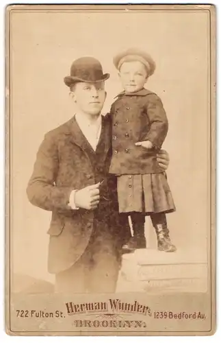 Fotografie Hermann Wunder, Brooklyn / NY, junger amerikanischer Vater mit seinem Kind im Atelier, Melone
