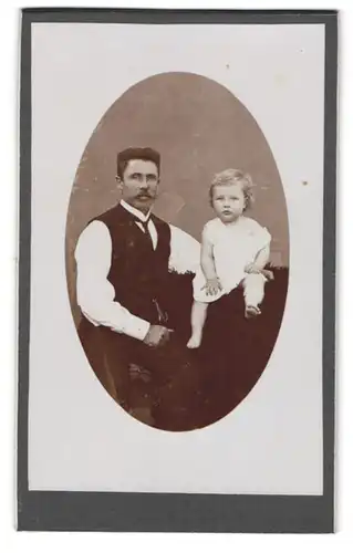 Fotografie unbekannter Fotograf und Ort, Vater im Anzug mit Tochter im weissen Leibchen posiert im Atelier