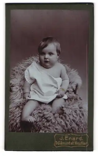 Fotografie J. Enard, Delemont, Avenue de la gare, Kleines Baby in weisser Kleidung auf einem Pelz