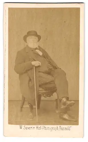 Fotografie W. Severin, Düsseldorf, Portrait stattlicher Herr mit grauem Bart und Flanierstock