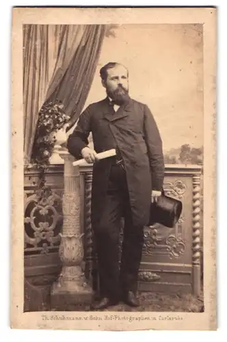 Fotografie Th. Schuhmann, Carlsruhe, Portrait charmanter Mann mit Vollbart und Zylinder in der Hand