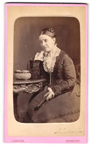 Fotografie J. Hawke, Plymouth, 8 George Street, Portrait brünette Dame mit Flechtdutt im prachtvollen Kleid