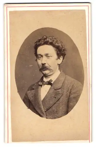 Fotografie Pierre Hunsanger, Ort unbekannt, Portrait stattlicher Herr mit lockigem Haar und Schnurrbart