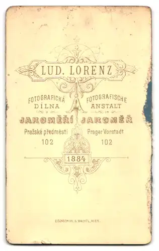 Fotografie L. Lorenz, Jaromer, Prager Vorstadt 102, Portrait niedliches Baby in Mütze und Kleidchen