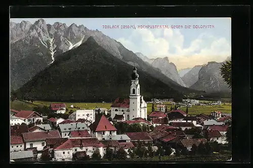 AK Toblach, Ortsansicht mit Kirche gegen die Dolomiten