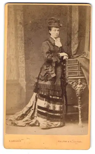 Fotografie E. Gregson, Halifax, Waterhouse St., Portrait einer elegant gekleideten Frau mit Hut