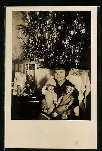 AK Glückliches Mädchen am Weihnachtsbaum, alle ihre Puppen aufgereiht