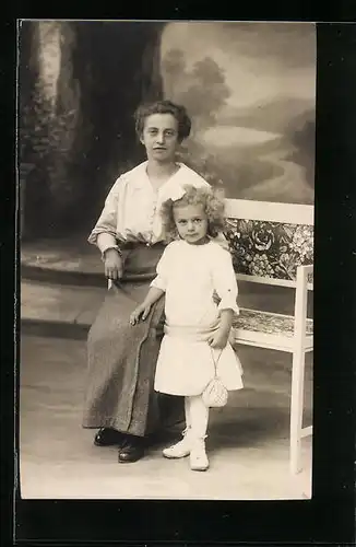 Foto-AK Mutter mit Kind auf einer Bank in einer Studiokulisse