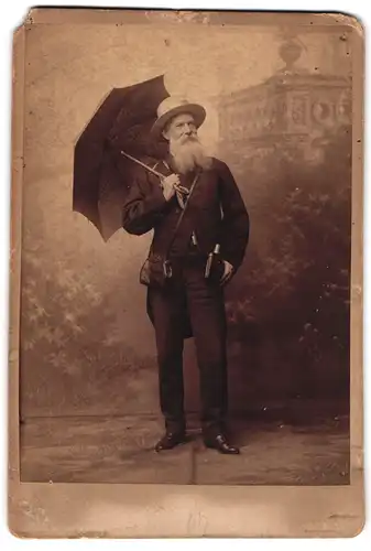 Fotografie unbekannter Fotograf und Ort, älterer Herr im Anzug mit aufgespannten Schirm und Trinkflasche am Gürtel