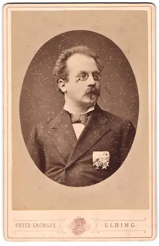 Fotografie Fritz Sachsze, Elbing, Portrait Herr Ernst Wernicker im Anzug mit Ordenspange und Zwickerbrille