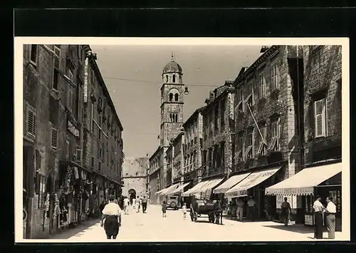 AK Korcula, Strassenpartie mit Geschäften und Passanten