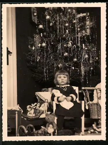 Fotografie Weihanchten, Mädchen mit Puppe, Teddybär & Spielzeug unterm Weihanchtsbaum sitzend