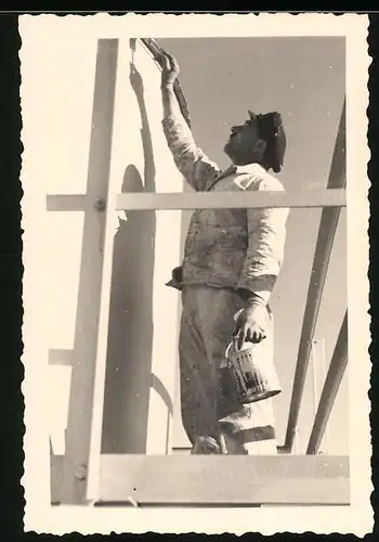 Fotografie Maler bei der Arbeit streicht die letzten Stellen einer Fassade