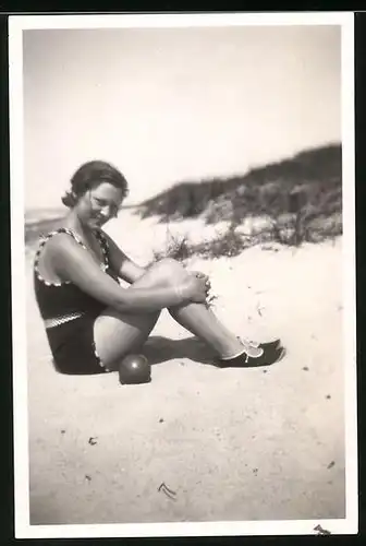 Fotografie bademode, Mädchen im Badeanzug am Strand sitzend