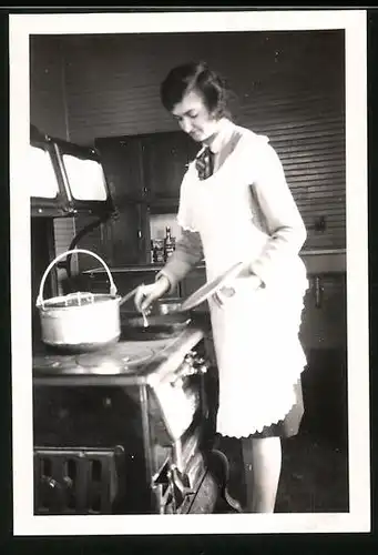 Fotografie junge Hausfrau beim Zubereiten einer Speise am Herd