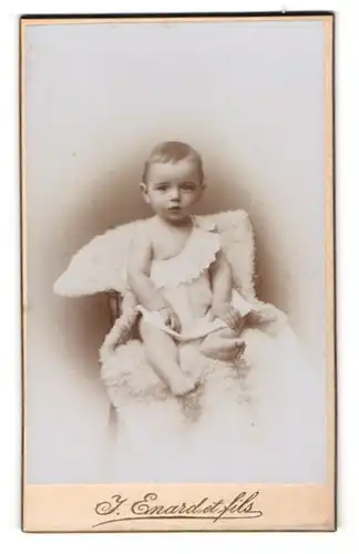 Fotografie J. Enard et fils, Delemont, Avenue de la gare, Baby in weissem Kleid auf einem Schaffell