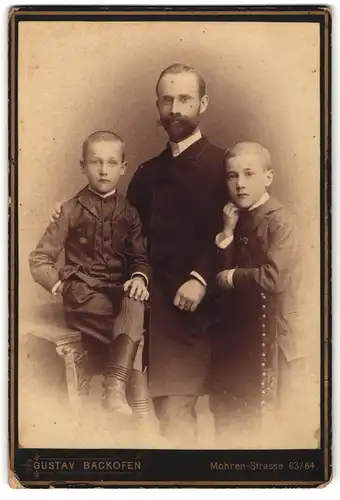 Fotografie Gustav Backofen, Berlin, Mohrenstrasse 63 /64, streng blickender Vater mit seinen beiden Söhnen
