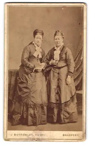 Fotografie J. Bottomley, Bradford, Portrait zwei elegant gekleidete Damen in eleganten Kleidern