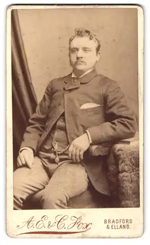 Fotografie A. E. & C. Fox, Bradford, Bridge Street, Portrait stattlicher Mann mit lockigem Haar im Anzug