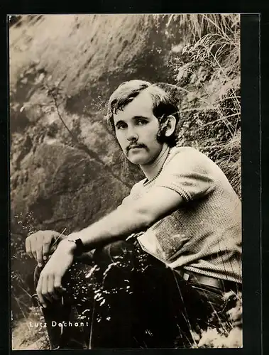 AK Schauspieler Lutz Dechant, an einem Hang sitzend