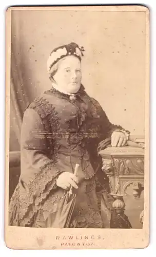 Fotografie Rawlings, Paignton, Portrait einer elegant gekleideten Frau mit Schirm in der Hand