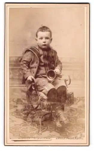 Fotografie Gebr. Bräm, Zürich-Aussersihl, Alte Rothwandstr., Portrait frecher Bube mit Spielzeug in der Hand