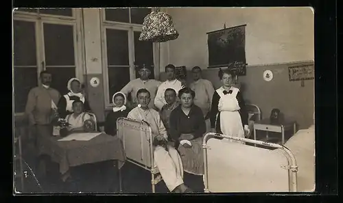 Foto-AK Gruppenaufnahme in einem Krankenzimmer mit Sanitätern des Roten Kreuzes